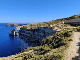 Vandrerute langs dramatiske kalkstensklipper med udsigt over det dybtblå Middelhav nær Xlendi og Dwejra på Gozo, Malta.